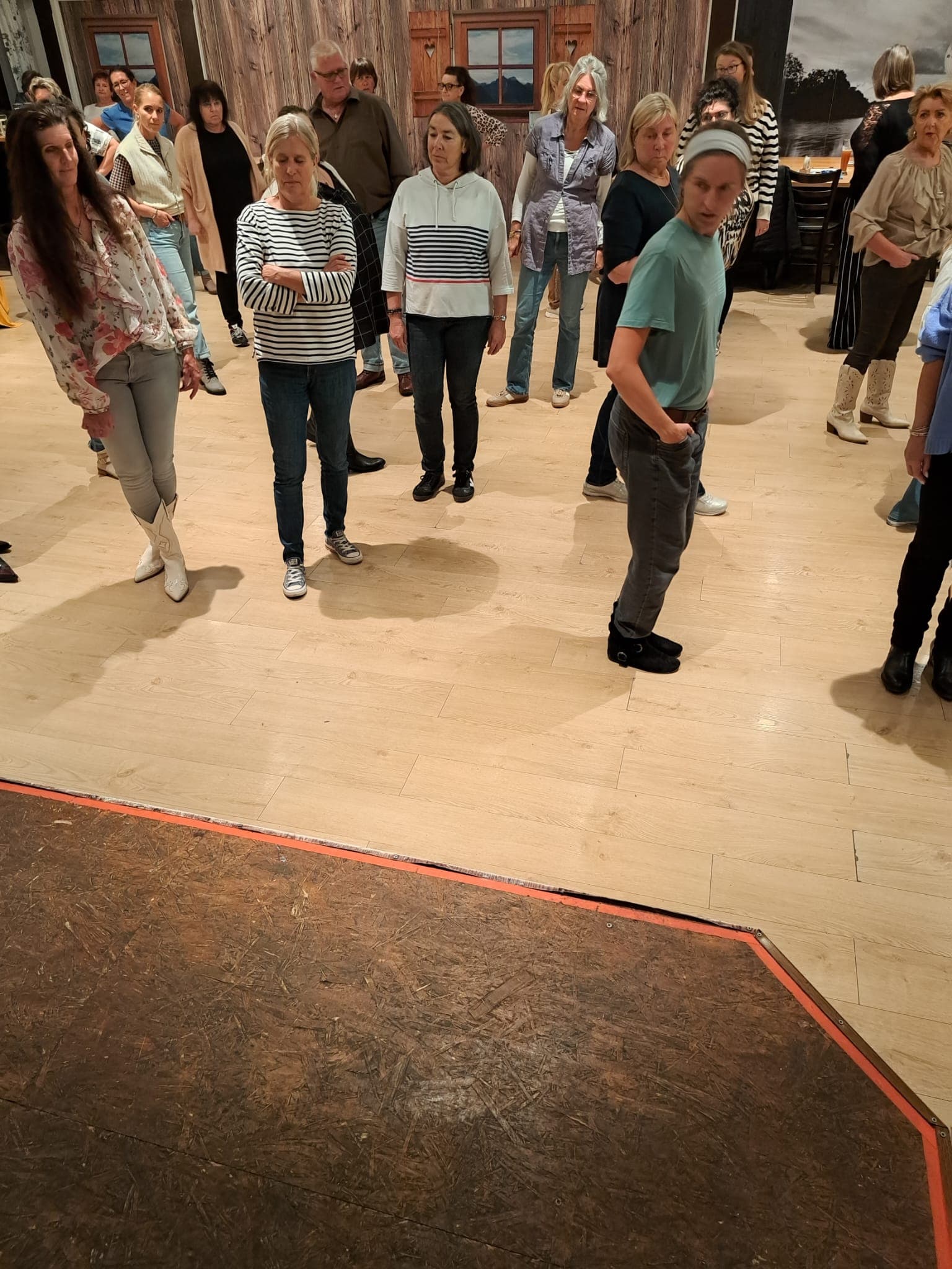 Die Gruppe auf dem hellen Holzboden, vorne die Bühne