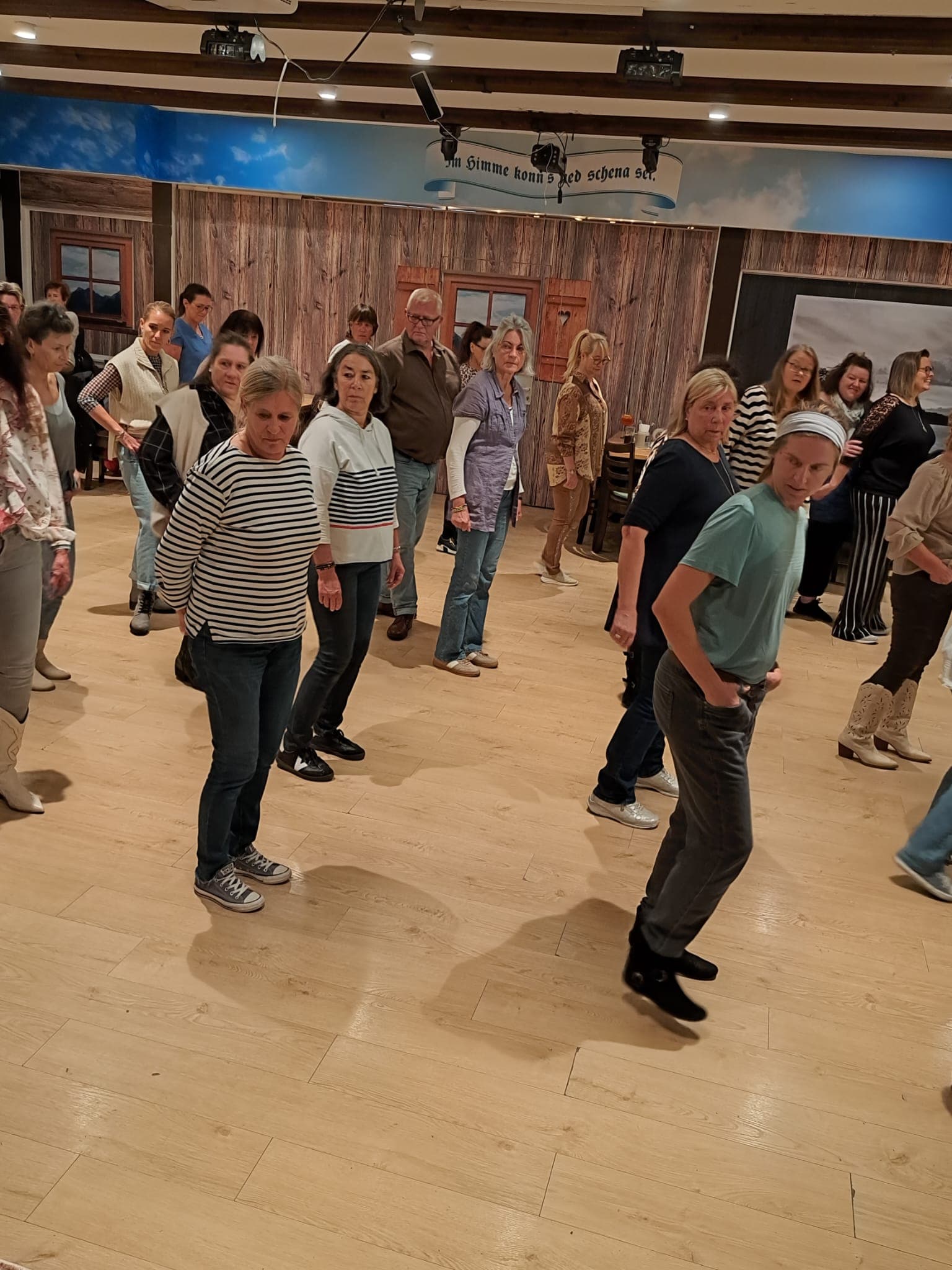 Die Gruppe tanzt gemeinsam in Reihen am Tanzplatz Dahoam in Olching